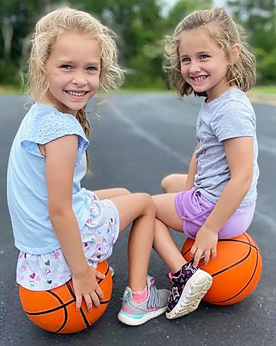 Creative-Kids-Family-lttle-girls-sitting-on-basketballs-smiling